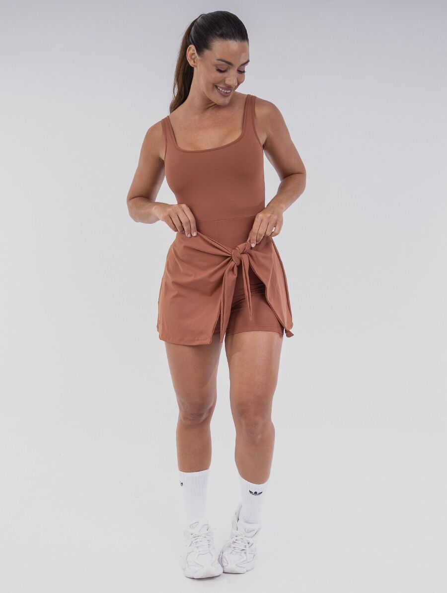 Vestido Macaquinho Terracota Belles Active com amarração frontal, short interno e Proteção UV 50+.