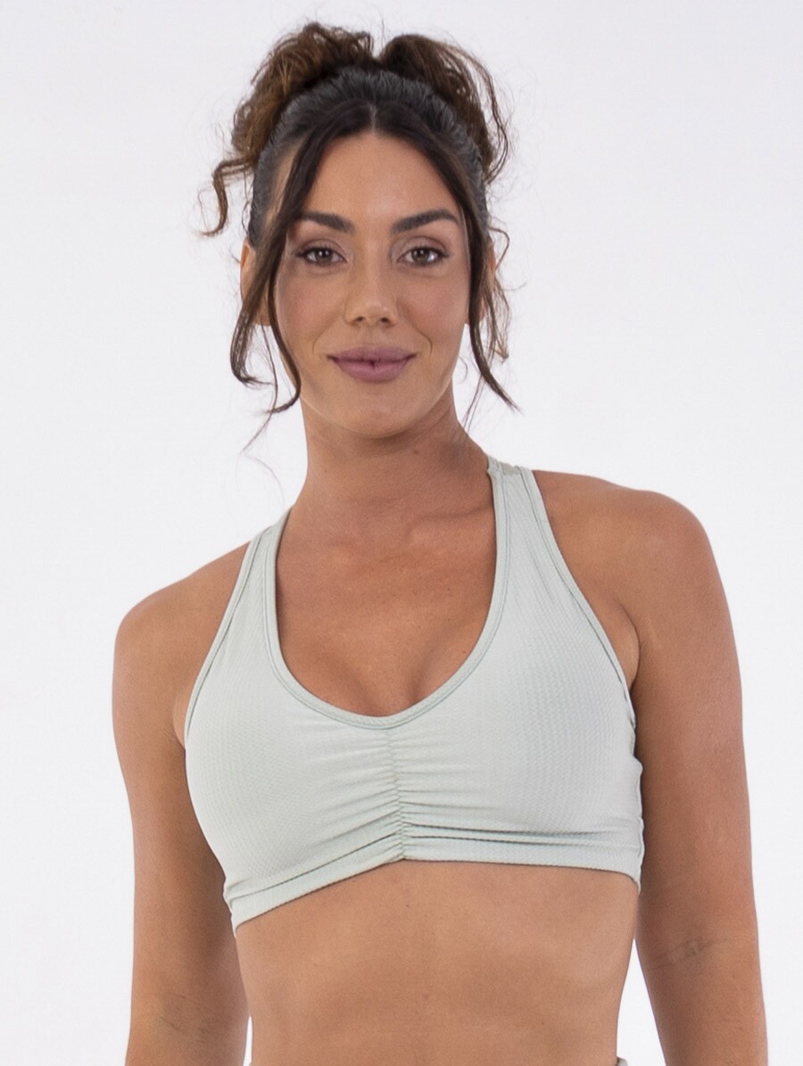 Top fitness verde Aloe com costas nadador, franzido central e bojos removíveis.