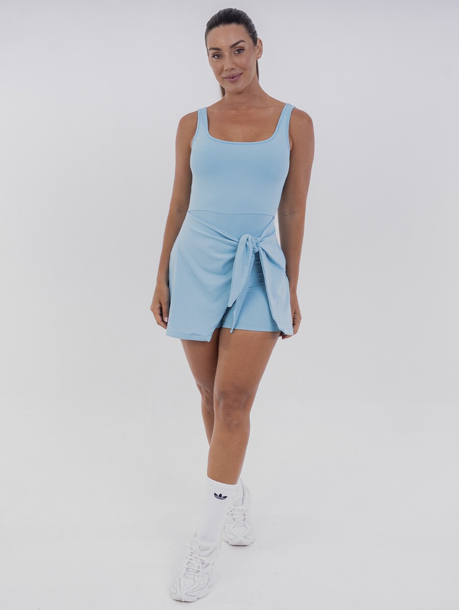 vestido-fitness-azul_4 Vestido macaquinho azul Azzure com short interno e saia sobreposta, amarração lateral ajustável e tecido com toque gelado e proteção UV 50+. Ideal para esportes como beach tennis e momentos de lazer.