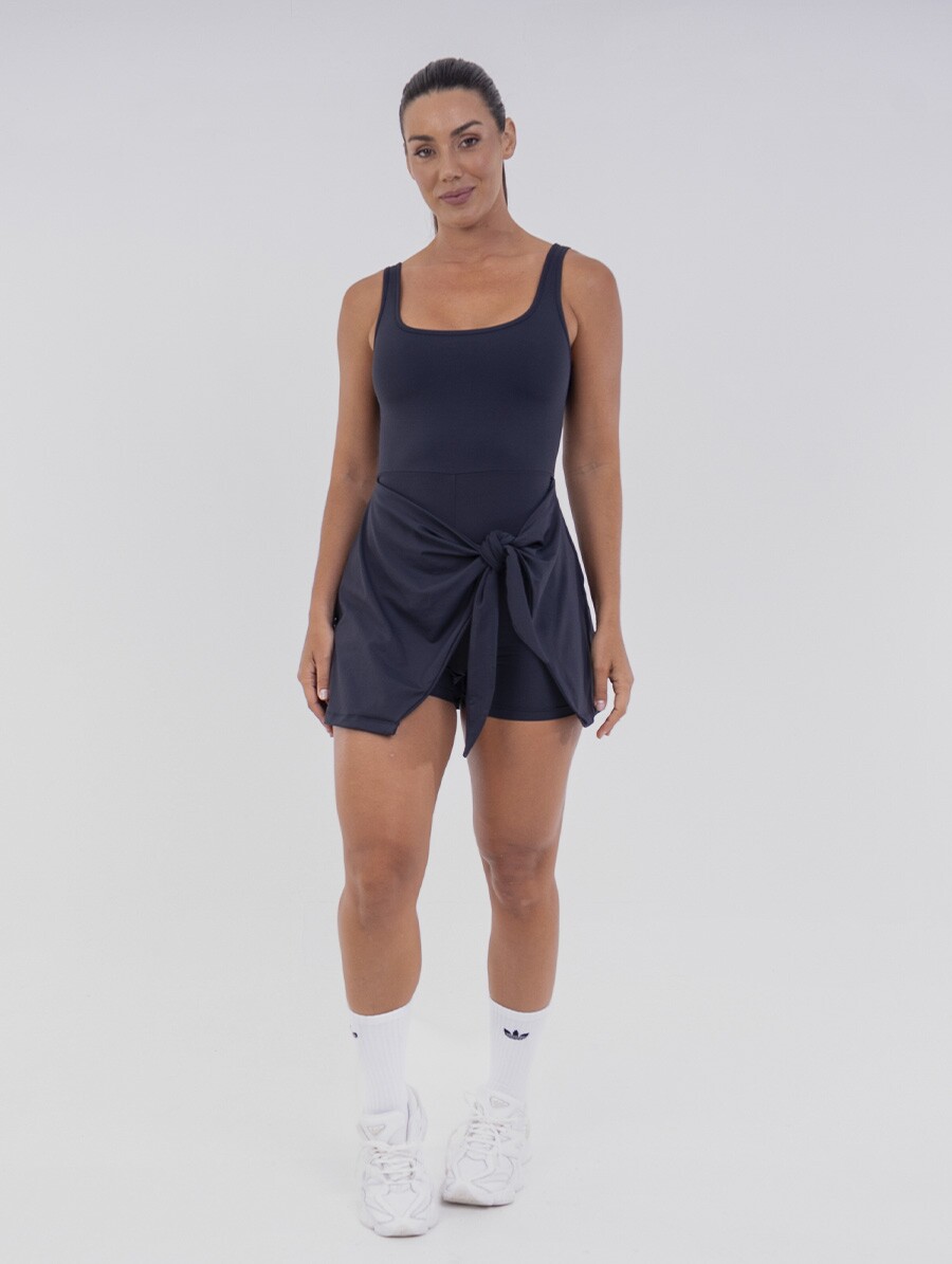 vestido-fitness-preto_4 Vestido Macaquinho Preto com short embutido e amarração lateral, ideal para treinos e momentos casuais.
